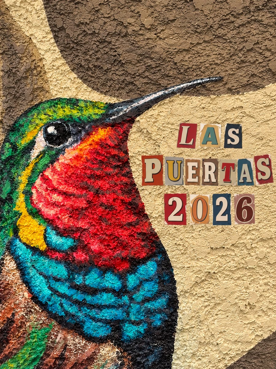Mural en relieve de un colibrí pintado sobre pared texturizada en el restaurante Las Puertas, con las letras LAS PUERTAS 2026 en rojo, azul y verde