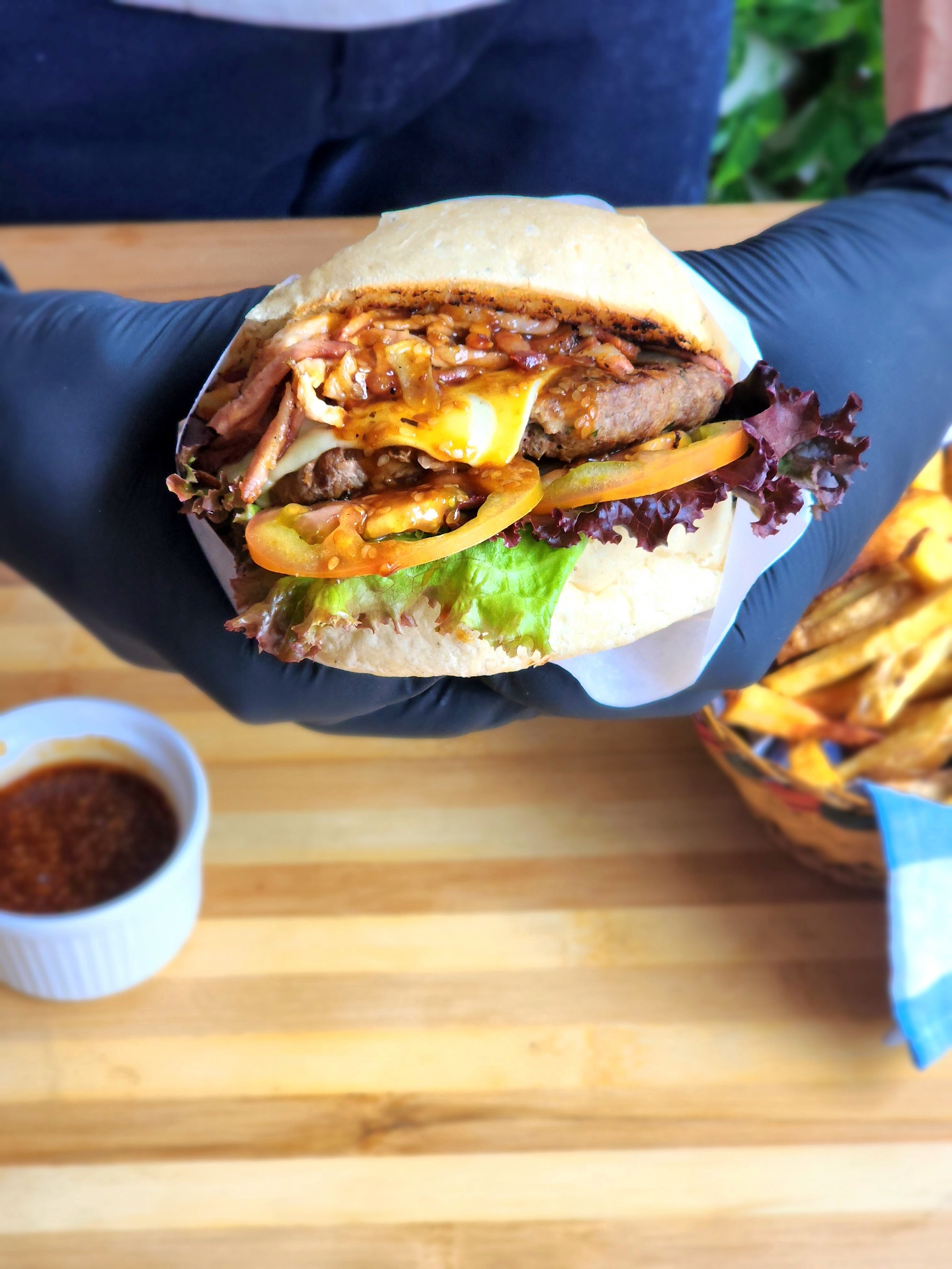 Hamburguesa de bondiola de temporada en Las Puertas Chía, ahumada al barril y servida con papas fritas